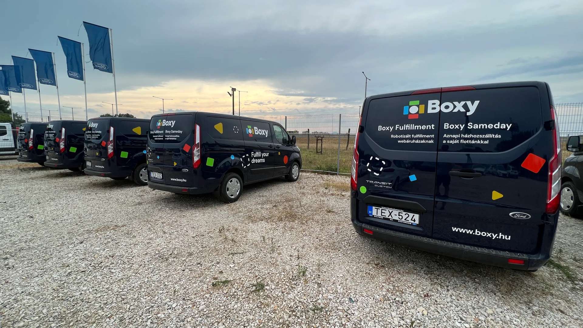 Boxy Ford Transit Custom flotta sunset – több sötétkék zárt áruszállító egységes Boxy arculattal, Fulfill your dreams tagline és színes formák