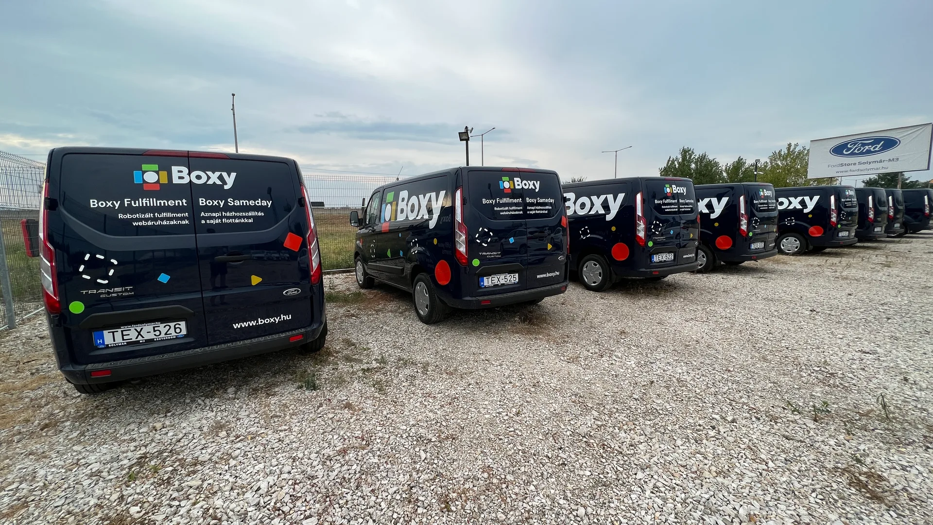 Boxy Transit Custom flotta hátulnézet – több jármű egységes hátsó dekorral, Boxy Fulfillment és Boxy Sameday szolgáltatási blokkok