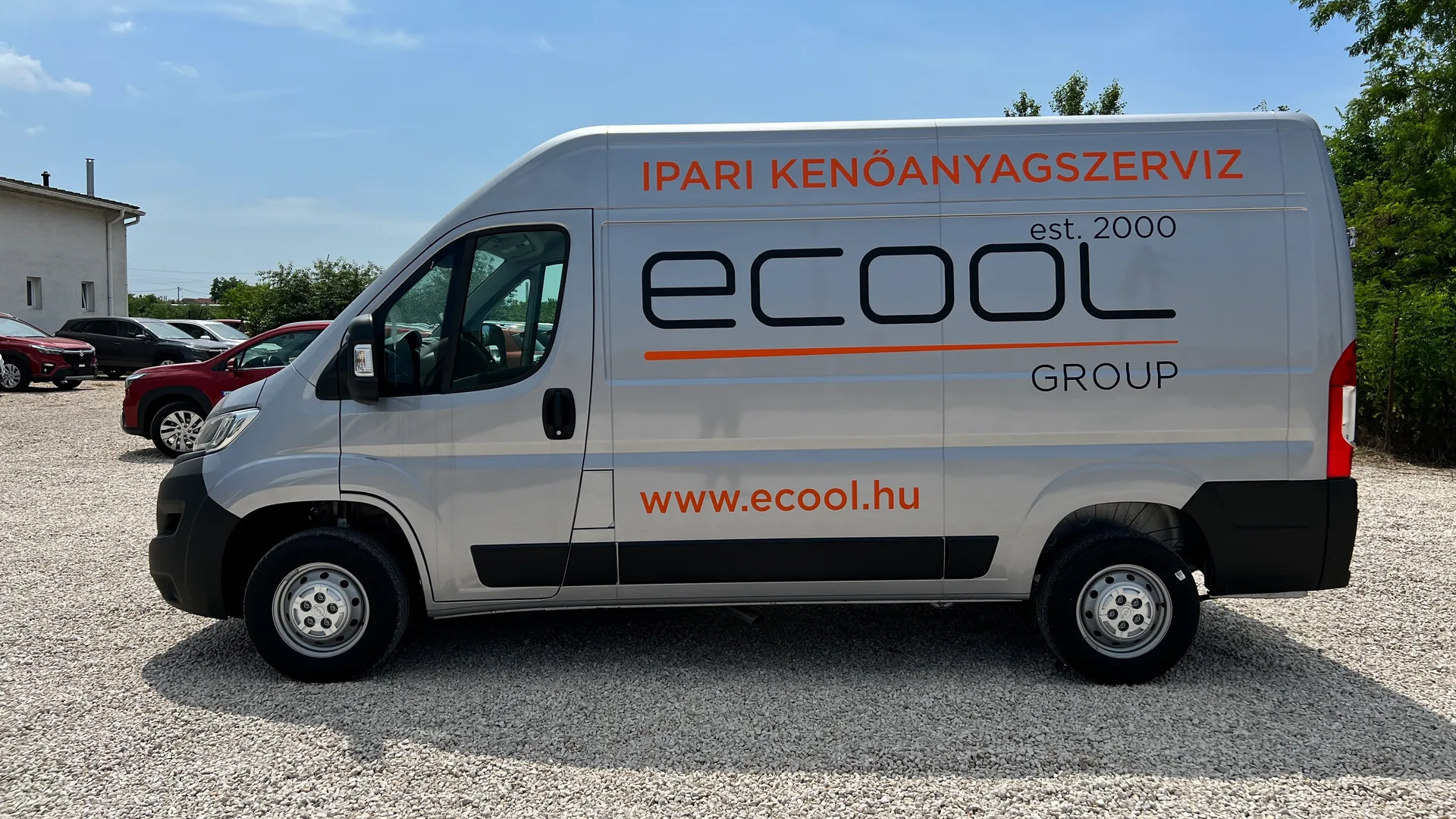 Ecool Opel Movano oldalnézet napsütésben – ezüst karosszéria, fekete ecool est. 2000 GROUP logó, narancssárga IPARI KENŐANYAGSZERVIZ felirat és www.ecool.hu weboldal