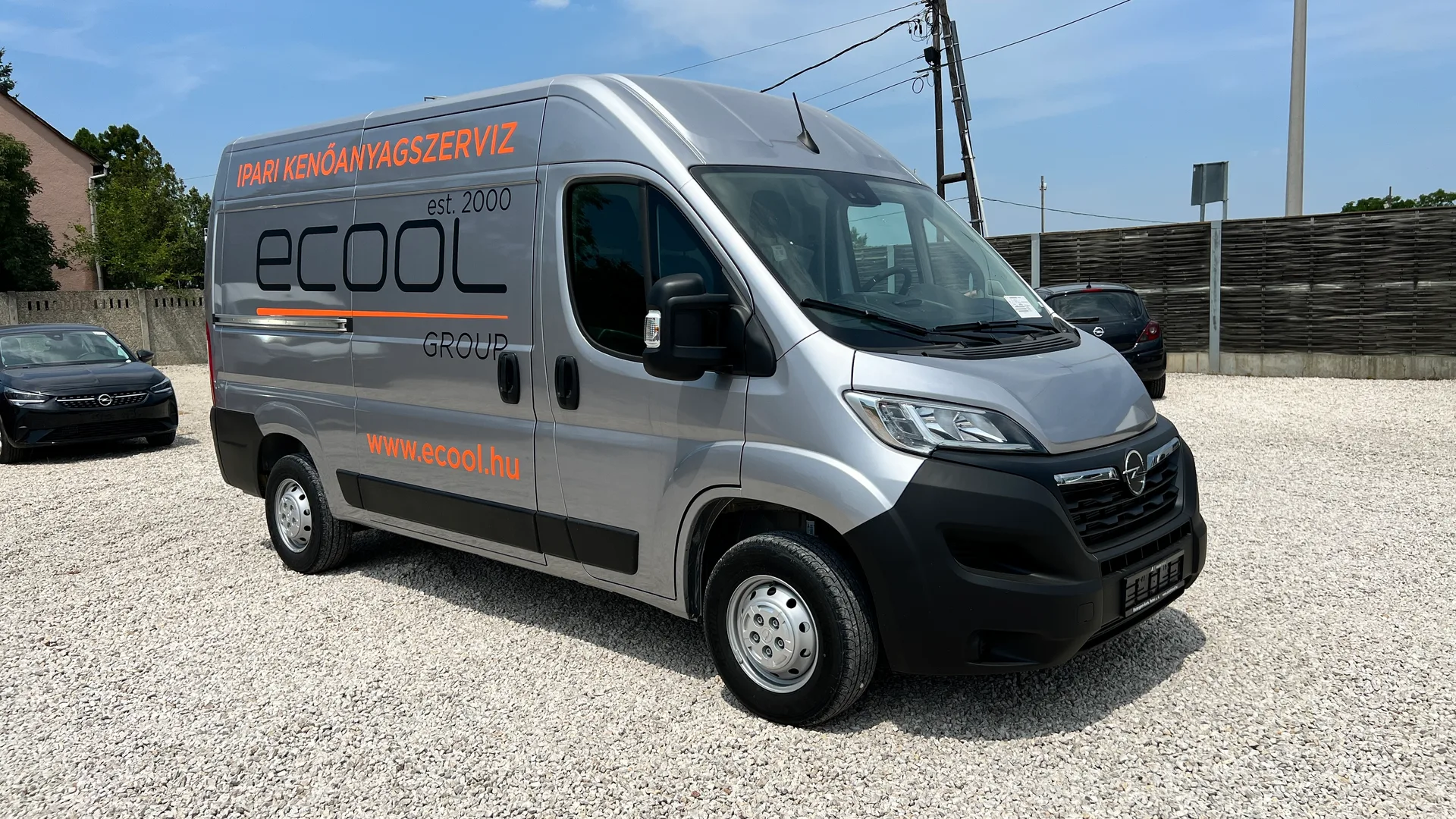 Ecool Opel Movano első és oldal nézet háromnegyedes szögből – ezüst karosszéria, ecool logó és narancssárga IPARI KENŐANYAGSZERVIZ felirat