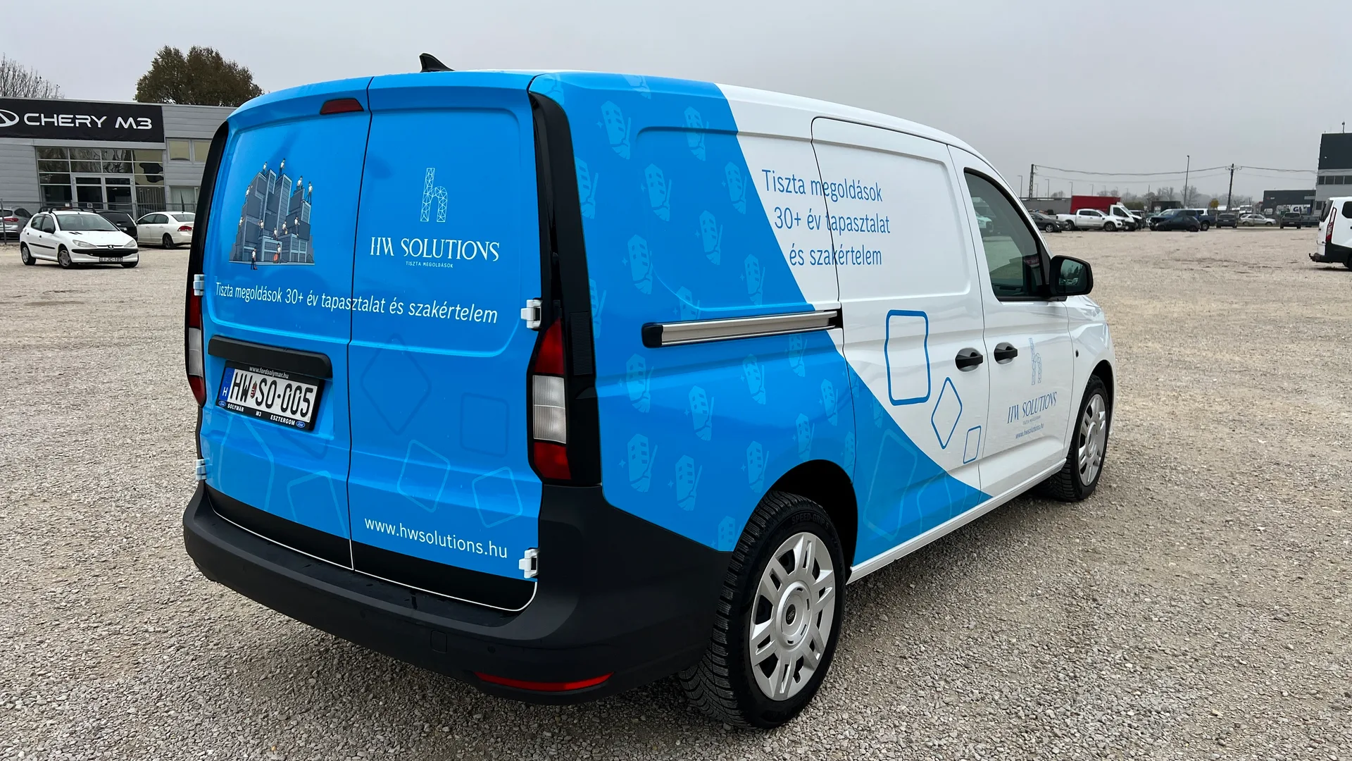 HW Solutions Ford Transit Connect Van bal hátsó negyedes nézet – kék hátsó ajtó az épülettisztítást ábrázoló illusztrációval és HW Solutions logóval