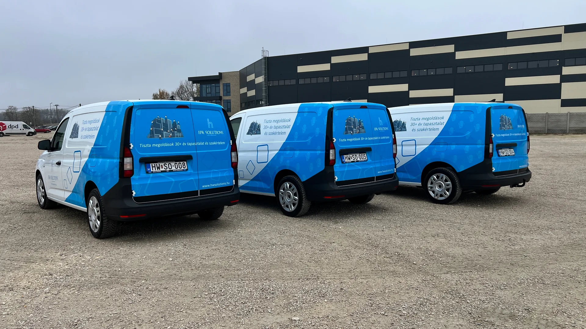 HW Solutions Ford Transit Connect flotta hátsó nézetből – három jármű egységes hátsó arculati kivitellel, kék hátsó ajtóval és épülettisztítás-illusztrációval