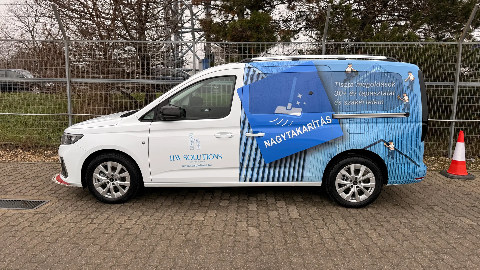 HW Solutions Ford Tourneo Connect járműdekoráció – fehér karosszérián kék épület-homlokzat grafika és karakteres NAGYTAKARÍTÁS elem