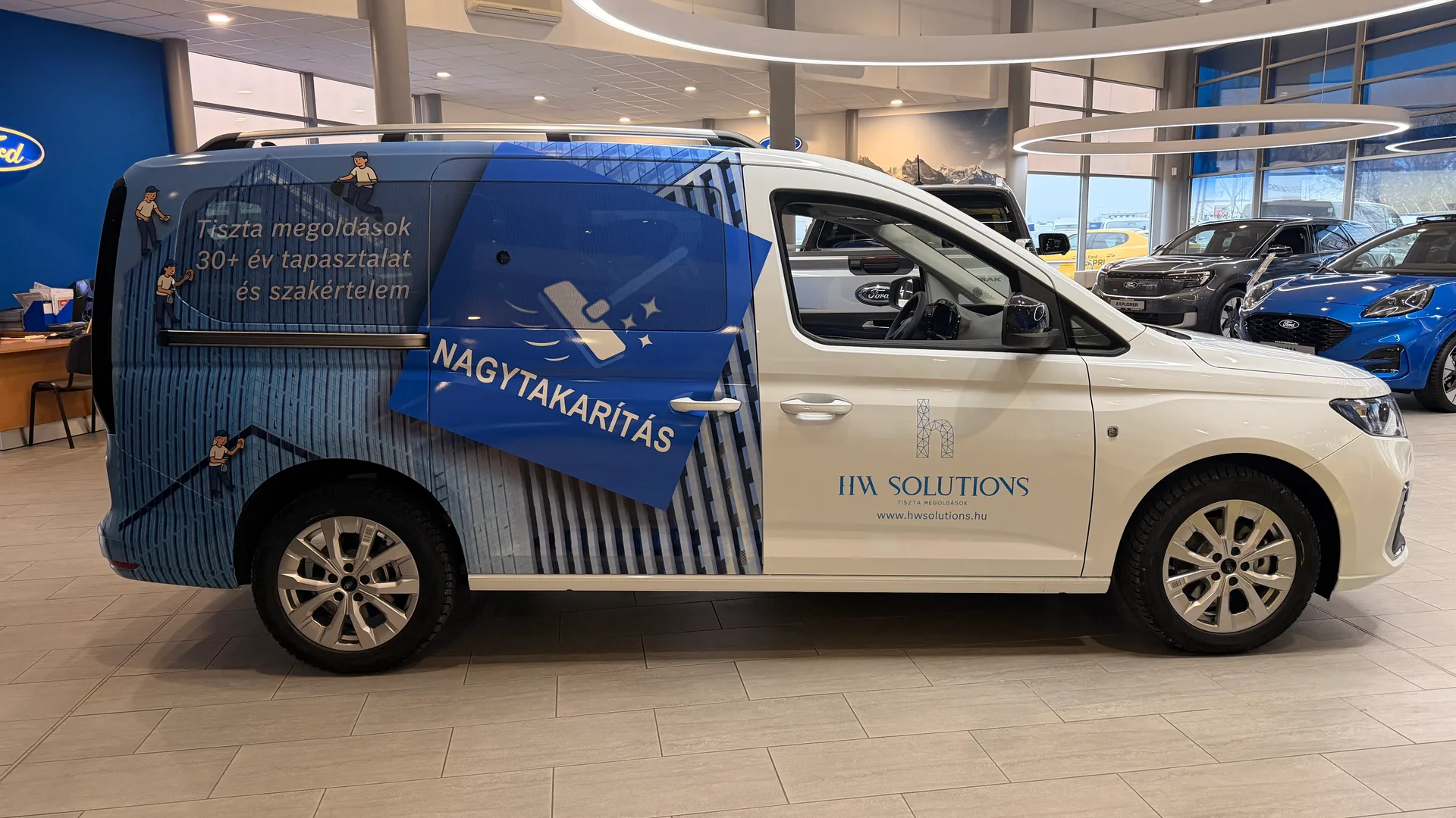HW Solutions Ford Tourneo Connect jobb oldali teljes nézet Ford márkakereskedésben – vágott HW Solutions logó, weboldal és nagyméretű NAGYTAKARÍTÁS elem