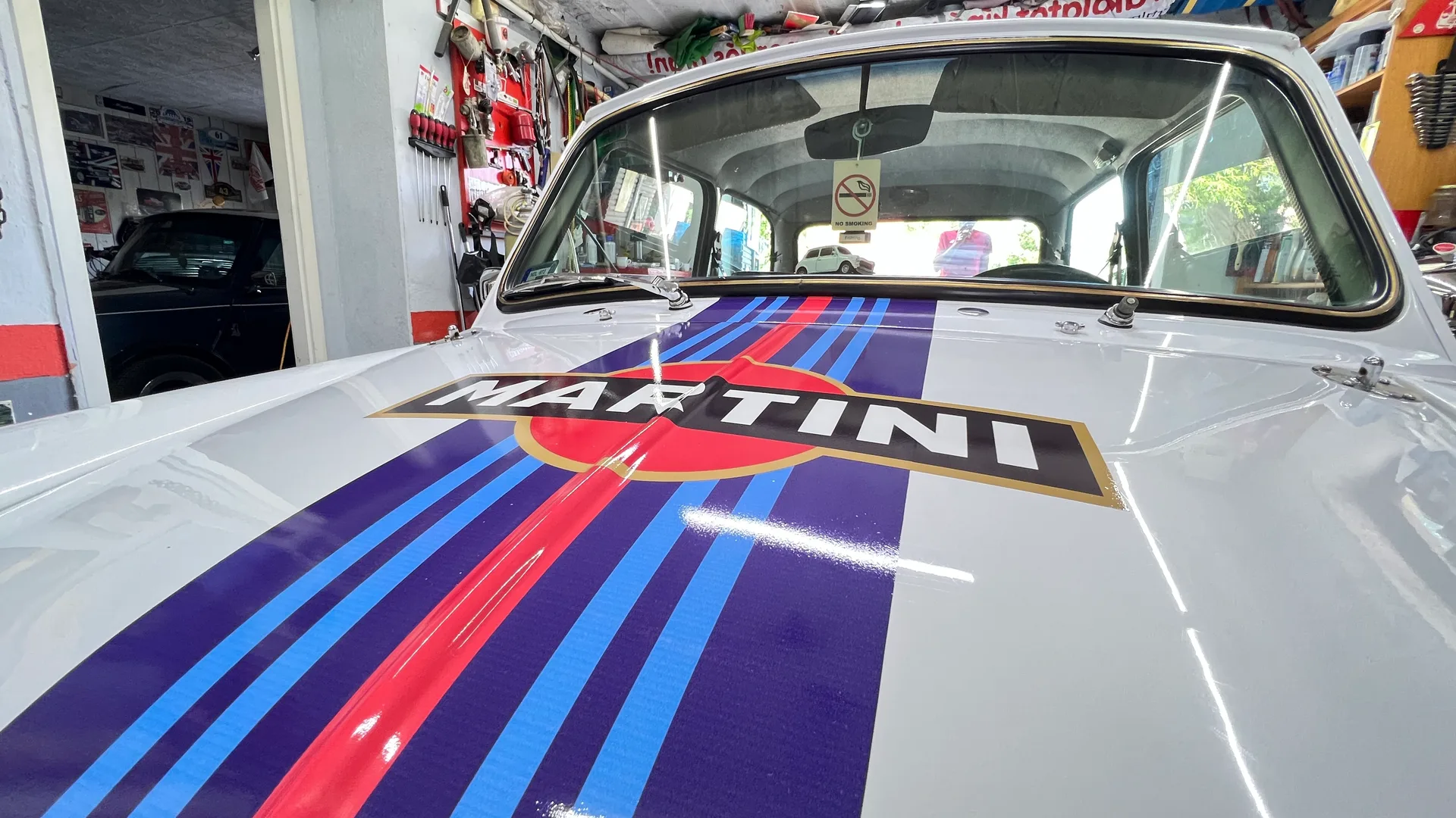 Klasszikus Mini motorháztetőjének közeli részletfotója a Martini Racing kék és piros csíkozással és a középre helyezett MARTINI logóval