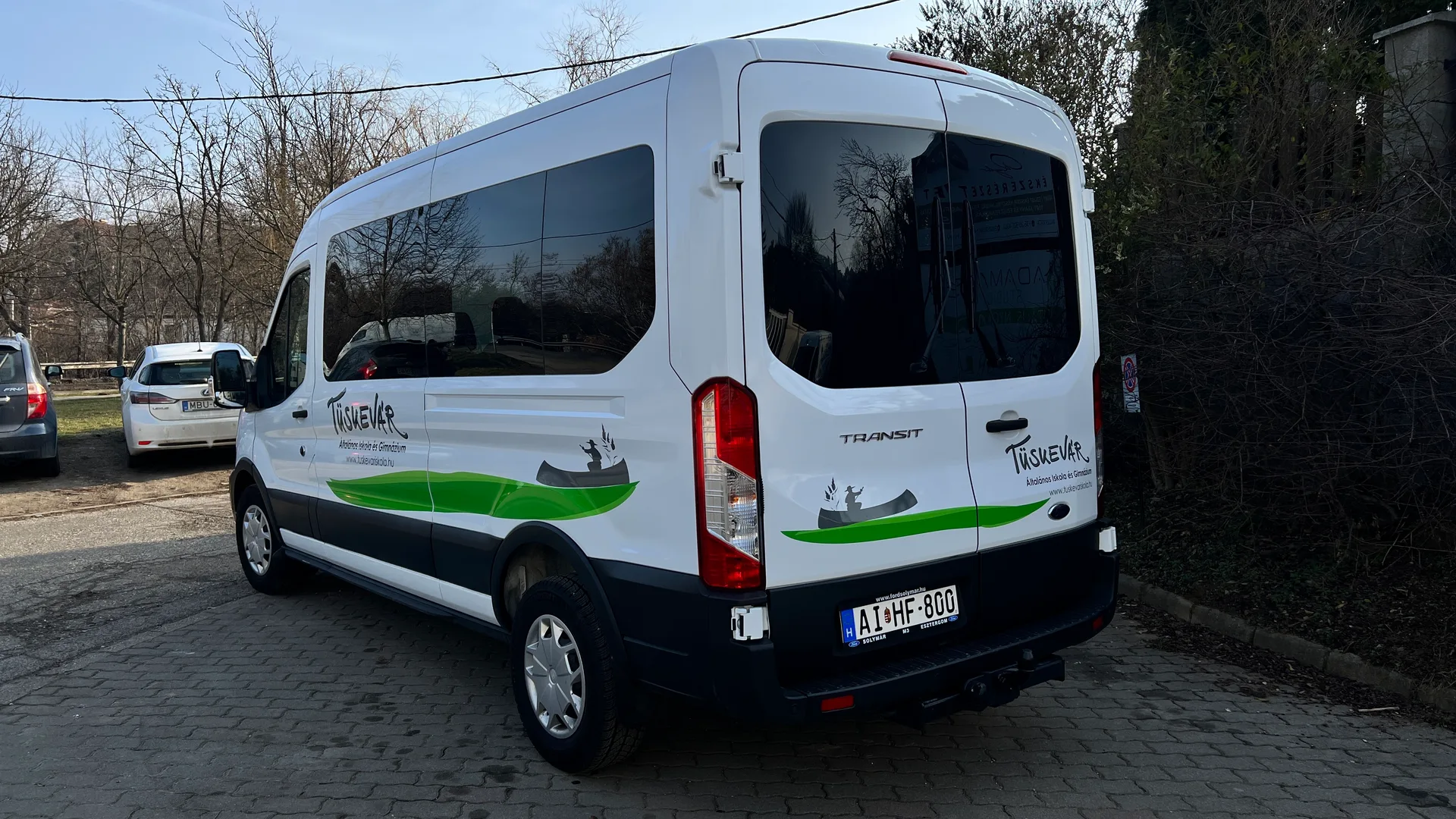 Hátsó-oldalsó nézet a Tüskevár iskola Ford Transit járművéről, az oldalsó és hátsó dekoráció folytatásával